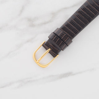 Close-up view of the authentic 18k yellow gold signed Audemars Piguet pin buckle on a brown leather strap