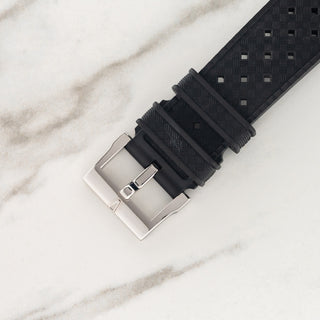 Close-up view of the stainless steel pin buckle and textured black tropic rubber strap on a Blancpain Fifty Fathoms