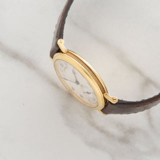 Side view displaying the signature coin-edge case detailing and sharp straight lugs on an unpolished 18k gold Breguet Classique