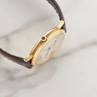Side profile view showcasing the ultra-slim 5mm case profile, sapphire cabochon crown, and coin-edge case rim of a Breguet 3210BA