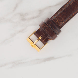 Close-up view of the authentic vintage Cartier New York double C signed pin buckle on a brown leather strap
