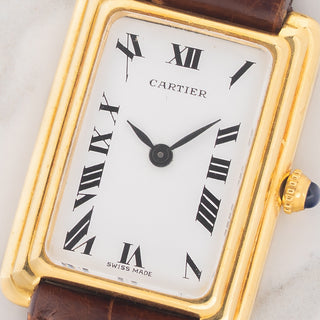 Macro close-up shot of the white dial with stretched black Roman numerals and blued steel hands on a 1975 Cartier Stepped Tank