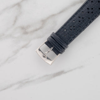 Close-up view of the stainless steel pin buckle on a black perforated rubber tropic strap