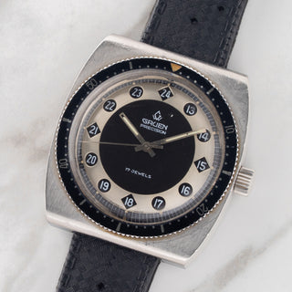 Angled shot highlighting the two-tone dial apertures and barrel-shaped steel case of a Gruen Airflight 27524