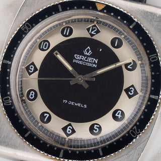 Macro close-up shot of the two-tone black and silver dial apertures and tritium hands on a Gruen Airflight