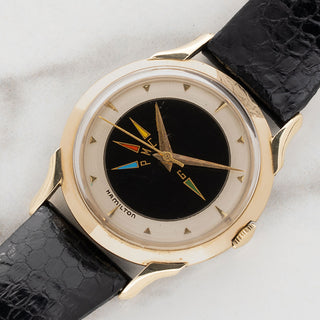 Angled shot highlighting the two-tone dial and sculpted lugs of a 1950s Hamilton Cross Country time zone watch