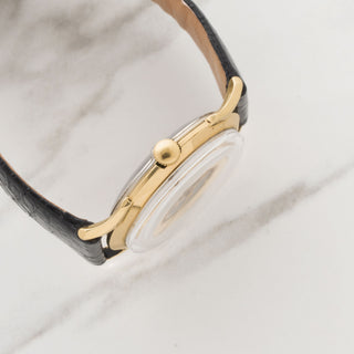 Side profile view showcasing the acrylic crystal and gold filled case profile with winding crown