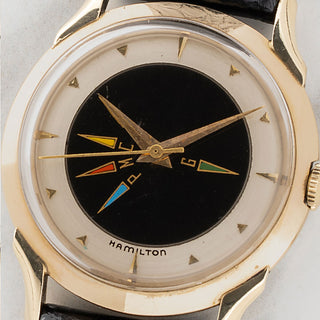 Macro close-up of the painted black center dial with multi-color time zone indicator hands set to EST on a vintage Hamilton