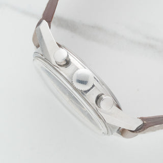 Side profile view showcasing the unpolished case lines, winding crown, and original chronograph pushers of a Heuer 3647NT