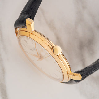 Side profile view showcasing the slim 37mm case profile, winding crown, and sharp shark fin lug edges of an IWC 521