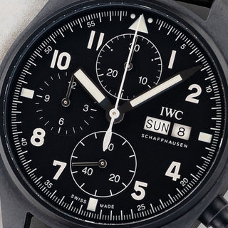Macro close-up shot of the black dial, straight-cut hour hand, day-date window, and subdial layout on an IWC Tribute to 3705 IW387905