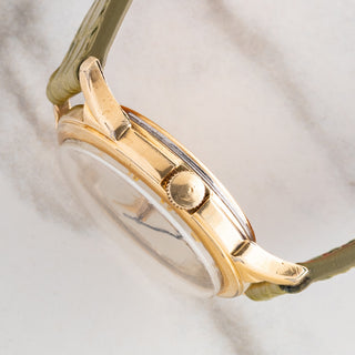Side profile view showcasing the 10k gold-filled case thickness, winding crown, and domed acrylic crystal on a LeCoultre Powermatic