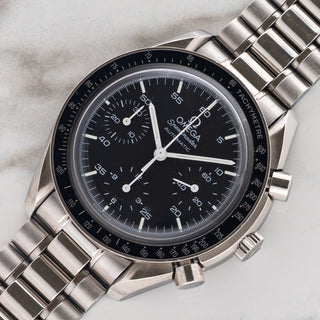 Angled shot highlighting the 39mm stainless steel case, tachymeter bezel insert, and Hesalite crystal on an Omega Speedmaster Reduced 3510.50