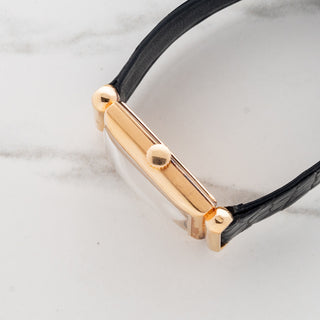 Side profile view showcasing the slim 18k rose gold rectangular case and crown housing the caliber 9-90 manual wind movement