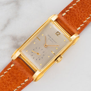 Angled shot highlighting the 18k yellow gold worked lug architecture and curved rectangular case on a Patek Philippe 2417J