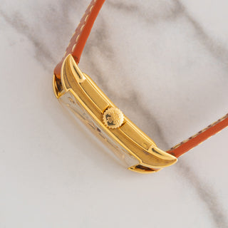 Side profile view showcasing the ergonomic curved 18k yellow gold case, winding crown, and domed crystal on a Patek Philippe 2417J