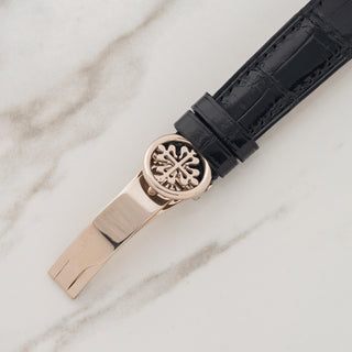Detail view of the signed platinum Calatrava cross folding deployant clasp on a black alligator strap