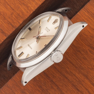 Angled top perspective showcasing the ultra-slim 8mm case profile, acrylic crystal, and signed crown on a Rolex 6426