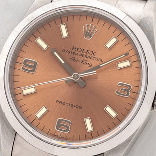Macro close-up shot of the salmon pink dial, 3-6-9 Arabic numerals, and warm tritium lume plots on a Rolex Air-King 14000