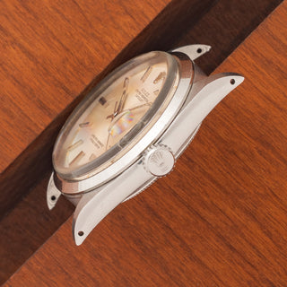 Angled top perspective showcasing the acrylic crystal, smooth bezel, and sharp lug lines on a Rolex 1600