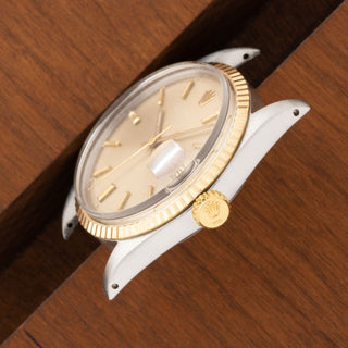 Angled top profile showing the thick stainless steel lug contours and gold fluted bezel of a Rolex 1601