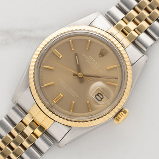 Angled view highlighting the unpolished 18k yellow gold fluted bezel and pie-pan dial profile of a Rolex Datejust 1601