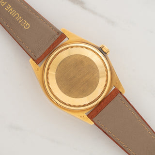 The solid 18k yellow gold Oyster caseback displaying sharp factory finishes and lug undersides on a Rolex 16018
