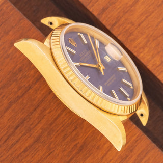 Angled top view highlighting the razor-sharp 18k gold lug proportions and matte blue dial on a 1984 Rolex Datejust