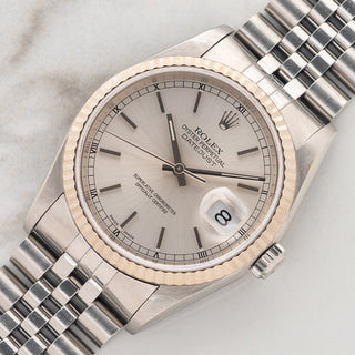Angled shot highlighting the 18k white gold fluted bezel and silver sunburst dial on a Rolex Datejust 16234