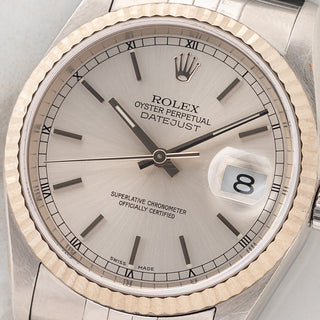 Macro close-up shot of the silver sunburst dial, Super-LumiNova hour markers, stick hands, and date cyclops on a Rolex Datejust 16234