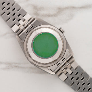 The stainless steel Oyster caseback retaining its original green Rolex factory hologram sticker on reference 16234