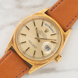 Angled shot highlighting the hand-engraved Florentine texture across the 18k yellow gold case and bezel on a Rolex Day-Date 1806