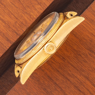 Angled top perspective showcasing the Florentine case finishing, signed winding crown, and acrylic crystal on a Rolex 1806