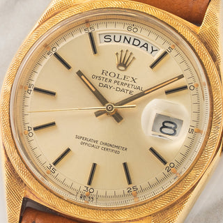 Macro close-up shot of the champagne pie-pan dial, warm tritium lume plots, and day-date apertures on a Rolex 1806