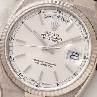 Macro view of the silver sunburst dial, day window, and date cyclops on a Rolex Day-Date Oysterquartz 19019