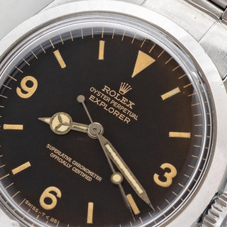 Angled shot highlighting the True Dome crystal, gilt dial printing, and stainless steel case on a Rolex Explorer 1016