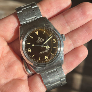 Handheld shot displaying the milk chocolate tones of the tropical gilt dial under direct light on a Rolex Explorer 1016