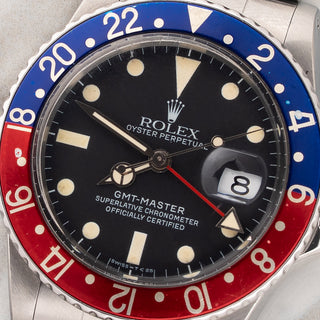 Macro close-up shot of the matte dial, egg shell patina lume plots, and red GMT hand on a vintage 16750