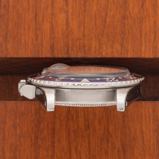 Horizontal profile view displaying the thick stainless steel case, visible lug chamfers, and acrylic crystal