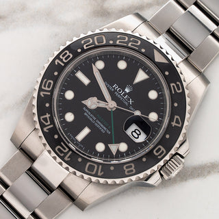 Angled shot highlighting the black Cerachrom ceramic bezel, green 24-hour hand, and stainless steel case of a Rolex 116710LN