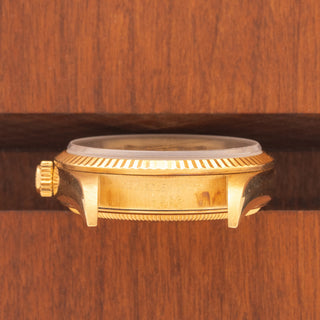 Horizontal case profile showing the fluted bezel and signed 18k gold winding crown on a Rolex 14238