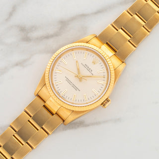 Unpolished 18k yellow gold Rolex Oyster Perpetual reference 14238 with silver dial and 7205 rivet bracelet at Collectors Corner NY