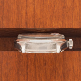 Horizontal case profile showing the sharp smooth bezel and clear 1600 reference engraving between the lugs