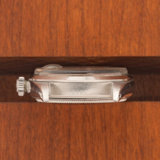 Horizontal case profile showing the signed winding crown and clear serial number engraving between the lugs