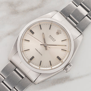 Angled shot highlighting the smooth stainless steel bezel and silver dial on a 1974 Rolex Oyster Precision 6426