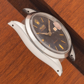 Angled top view highlighting the thick lug proportions and black gilt dial of a 1959 Rolex Oysterdate