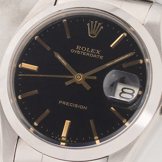 Macro close-up shot of the mirror-like black glossy gilt dial, gold hands, and warm tritium plots on a Rolex 6694