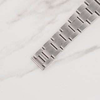 Top view displaying the brushed solid stainless steel Oyster bracelet links and 557 end links on a Rolex 6694