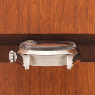Horizontal case profile showing the signed winding crown and clear 5.7M serial number engraving between the lugs
