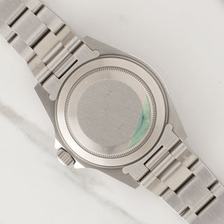 Clean stainless steel Oyster caseback with original factory green caseback sticker trace on a Rolex 14060M
